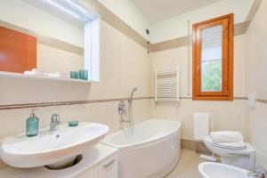 a white bathroom with a sink and a toilet at Magnolia: Laveno Centre 2BR with Terrace - Happy Rentals in Laveno-Mombello