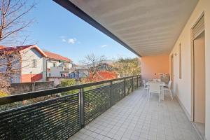 a balcony with a table and chairs on it at Magnolia: Laveno Centre 2BR with Terrace - Happy Rentals in Laveno-Mombello +14 photos