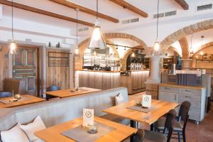 a restaurant with wooden tables and chairs and a kitchen at Thalinger Hof in Kronstorf