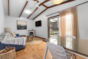 a living room with a couch and a table at Lakes Edge Retreat in Yungaburra