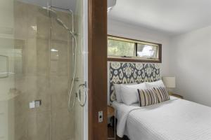 a bedroom with a bed and a glass shower at Lakes Edge Retreat in Yungaburra +76 photos