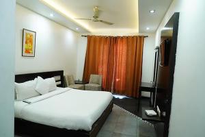 a bedroom with a large white bed and a window at Hotel Raunak in Pinjaur +5 photos