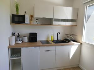 a white kitchen with a sink and a microwave at Studio de Marie in Bordeaux-Saint-Clair