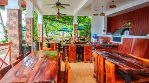 a restaurant with wooden tables and wooden chairs at The Lei's Hotel and Beach Resort in Mercedes