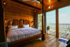 a bedroom with a bed and a large window at Koro Treehouse Resort Luxury Jacuzzi Cottages and Jacuzzi Villas in Kasauli