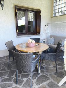 a table and chairs in a room with a couch at CasaDolcelago Sulzano Villa con Giardino Vista Lago Parking Free in Sulzano +19 photos