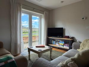 a living room with a couch and a tv and a table at The Old Garage in Rural Northumberland in Edlingham