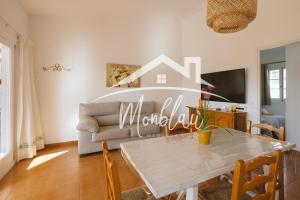 a living room with a table and a couch at Sa Torreta 4 in Cala Blanca