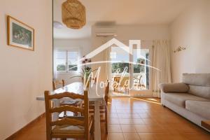 a living room with a table and a couch at Sa Torreta 4 in Cala Blanca