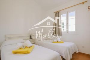 two beds in a room with a house on the wall at Sa Torreta 4 in Cala Blanca +22 photos