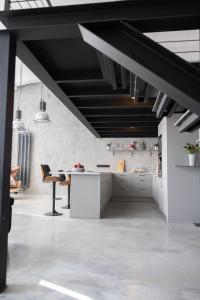 a kitchen with white cabinets and a black ceiling at Chaya Niwas Loft in Żyrardów