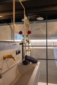 a vase with a flower on a counter in a bathroom at Chaya Niwas Loft in Żyrardów