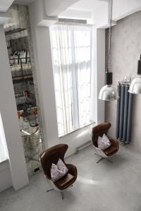two chairs in a room with a large window at Chaya Niwas Loft in Żyrardów +23 photos