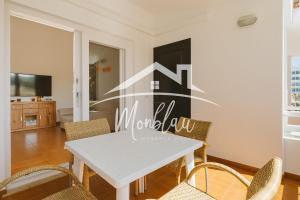 a dining room with a white table and chairs at Sa Torreta 3 in Cala Blanca