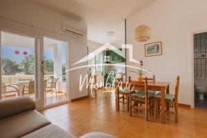 a dining room and living room with a table and chairs at Sa Torreta 3 in Cala Blanca