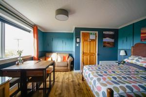 a bedroom with a bed and a desk and a table at Burnside Cottage in Wick