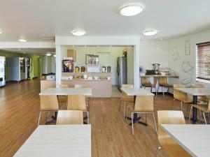 a cafeteria with tables and chairs and a kitchen at Coffs Harbour Budget Stay in Coffs Harbour