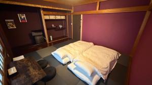 a small bedroom with a bed and a table at hostel大黒屋 in Miyoshi