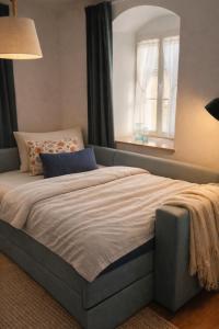 a large bed in a bedroom with a window at Gutshof 1600 in Hohnstein