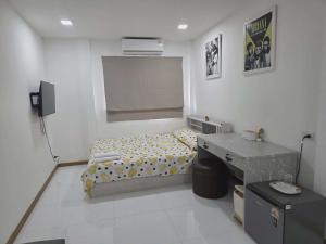 a small bedroom with a bed and a desk at Hugg daily airport in Ban Khlong Thewa