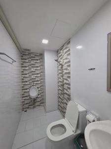 a bathroom with a toilet and a sink at Hugg daily airport in Ban Khlong Thewa