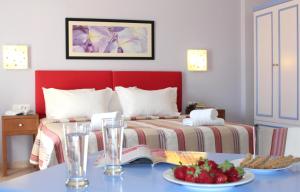 a bedroom with a bed and a table with a book at Amaryllis Hotel Apartments in Tolo +46 photos