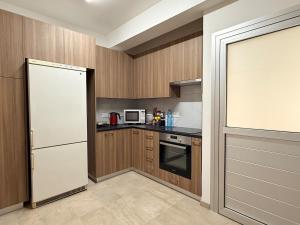 a kitchen with wooden cabinets and a white refrigerator at Nicosia Neoclassic Retreat in Nicosia