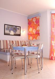 a dining room with a blue table and chairs at Amaryllis Hotel Apartments in Tolo