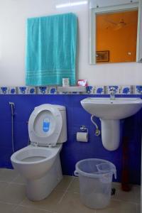 Baño azul con aseo y lavamanos en Misty Rosa Luxury Serviced Apartments, en Kottayam