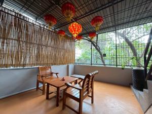 a dining room with a table and chairs and lanterns at Merge Hostel Chinatown in Samphanthawong