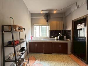 a small kitchen with a sink and a microwave at Merge Hostel Chinatown in Samphanthawong +76 photos
