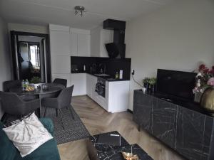 a living room with a table and a kitchen at Luxe Studio Liemers in Lelystad