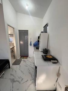 a white kitchen with a counter and a refrigerator at Blueznest in Babag Island +9 photos