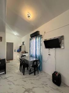 a living room with a table and a tv on the wall at Blueznest in Babag Island