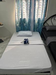 a pair of beds in a room with a window at Blueznest in Babag Island