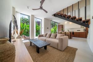 a living room with a couch and a table at Lily Villas - Rice Field Views Escape with Private Pool in Canggu