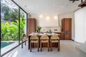 a kitchen and dining room with a table and chairs at Lily Villas - Rice Field Views Escape with Private Pool in Canggu