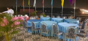 a group of blue tables and chairs and a man at CHETAN INN HOTEL in Bhubaneshwar