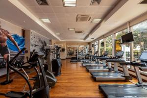 a gym with a row of treadmills and ellipticals at Constellation Apartments in Kampala