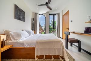 a bedroom with a large bed and a window at Lily Villas - Rice Field Views Escape with Private Pool in Canggu