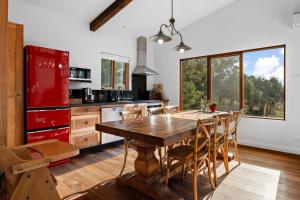 a kitchen with a wooden table and a red refrigerator at Adventure Bay Retreat Bruny Island in Adventure Bay +17 photos