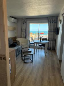 a living room with a table and a view of the ocean at sol appart hotel in Banyuls-sur-Mer