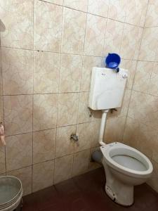 a bathroom with a toilet with a blue object on it at Star Hostel in Kannur