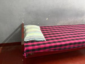 a bed with a striped pillow on top of it at Star Hostel in Kannur +11 photos