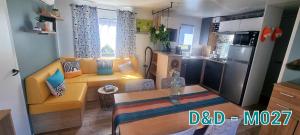 a small kitchen and living room with a couch and a table at Camping les dunes Torreilles Plages - Bungalow M027 chez D&D in Torreilles