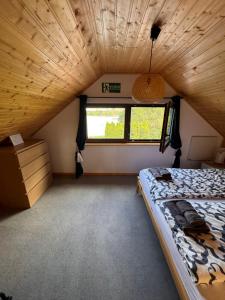 a bedroom with a bed in a tiny house at SOCHÓWKA nad Jeziorem Skarlińskim in Kurzętnik