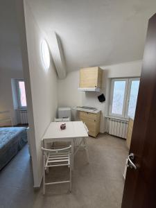 ein kleines Zimmer mit einem Tisch und einem Bett in der Unterkunft Cielo in Mele
