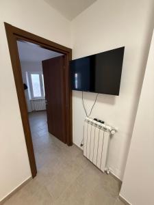 ein Zimmer mit einem Flachbildfernseher an der Wand in der Unterkunft Cielo in Mele