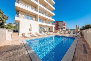 a swimming pool in front of a building at ARA Lux Apartments in Utjeha