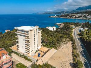 a white building on a hill next to the ocean at ARA Lux Apartments in Utjeha